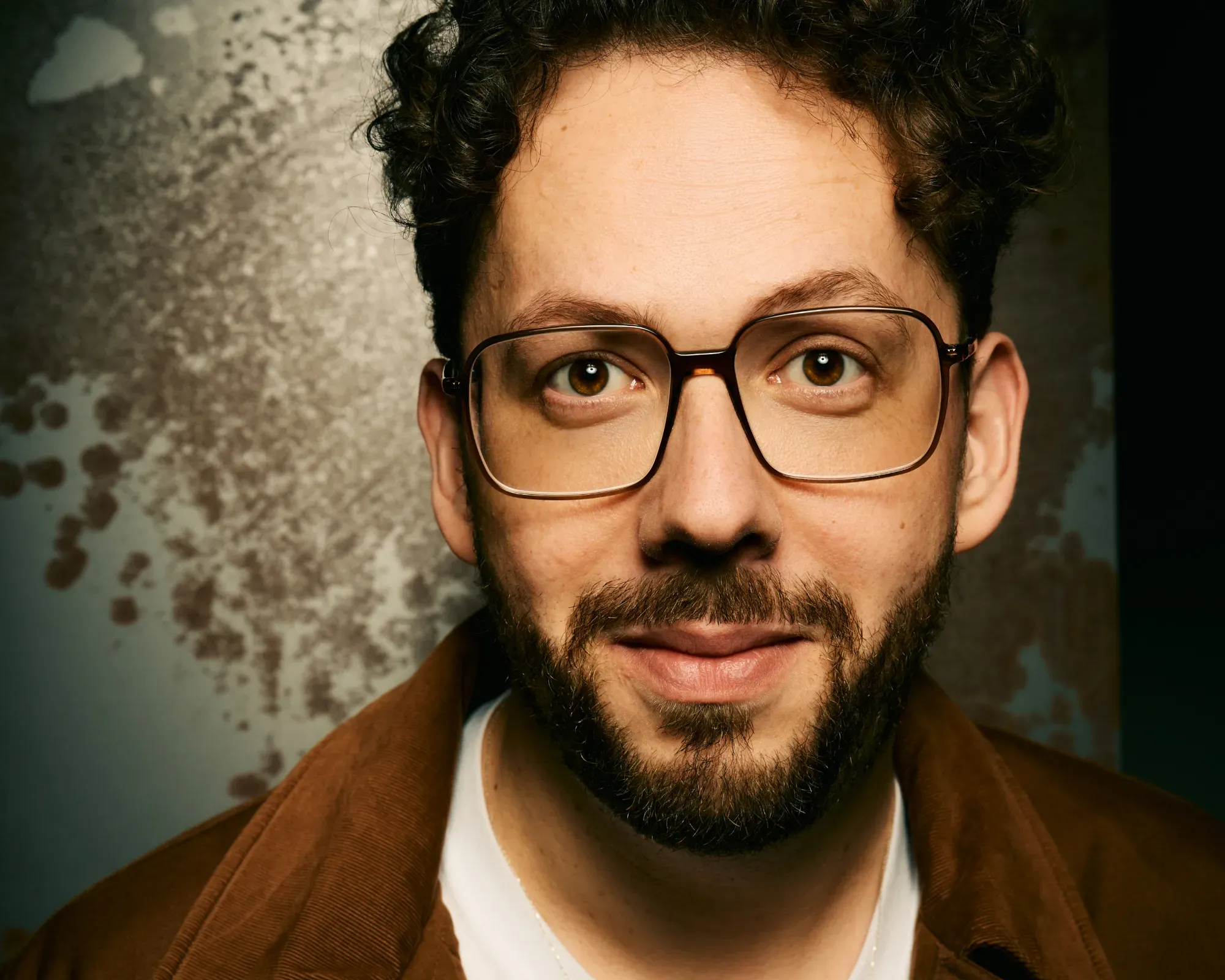 Portrait von Henrik Szántó vor einem Kunstwerk